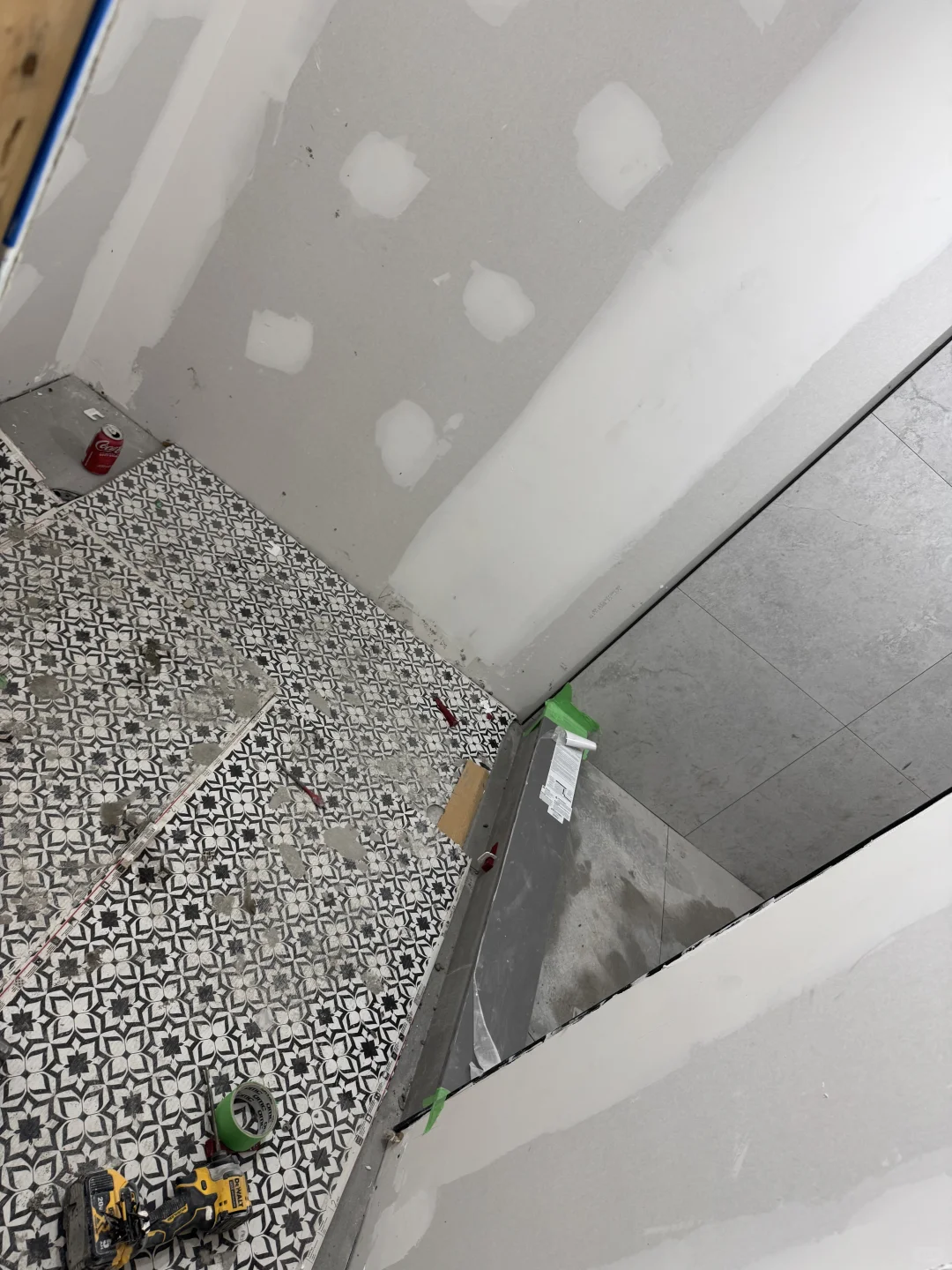 Patterned bathroom floor and shower tile installation in progress