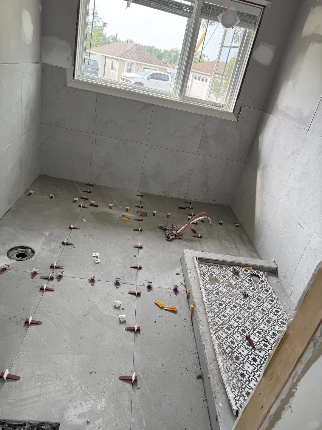 Bathroom floor and shower base tile installation in progress