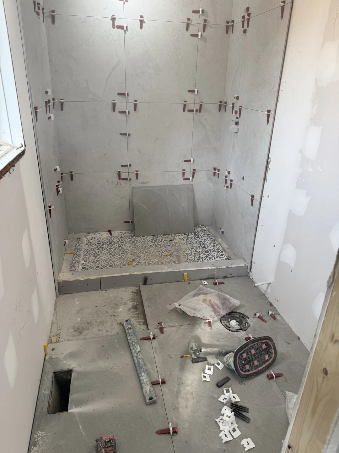 Large-format shower wall tile installation in progress